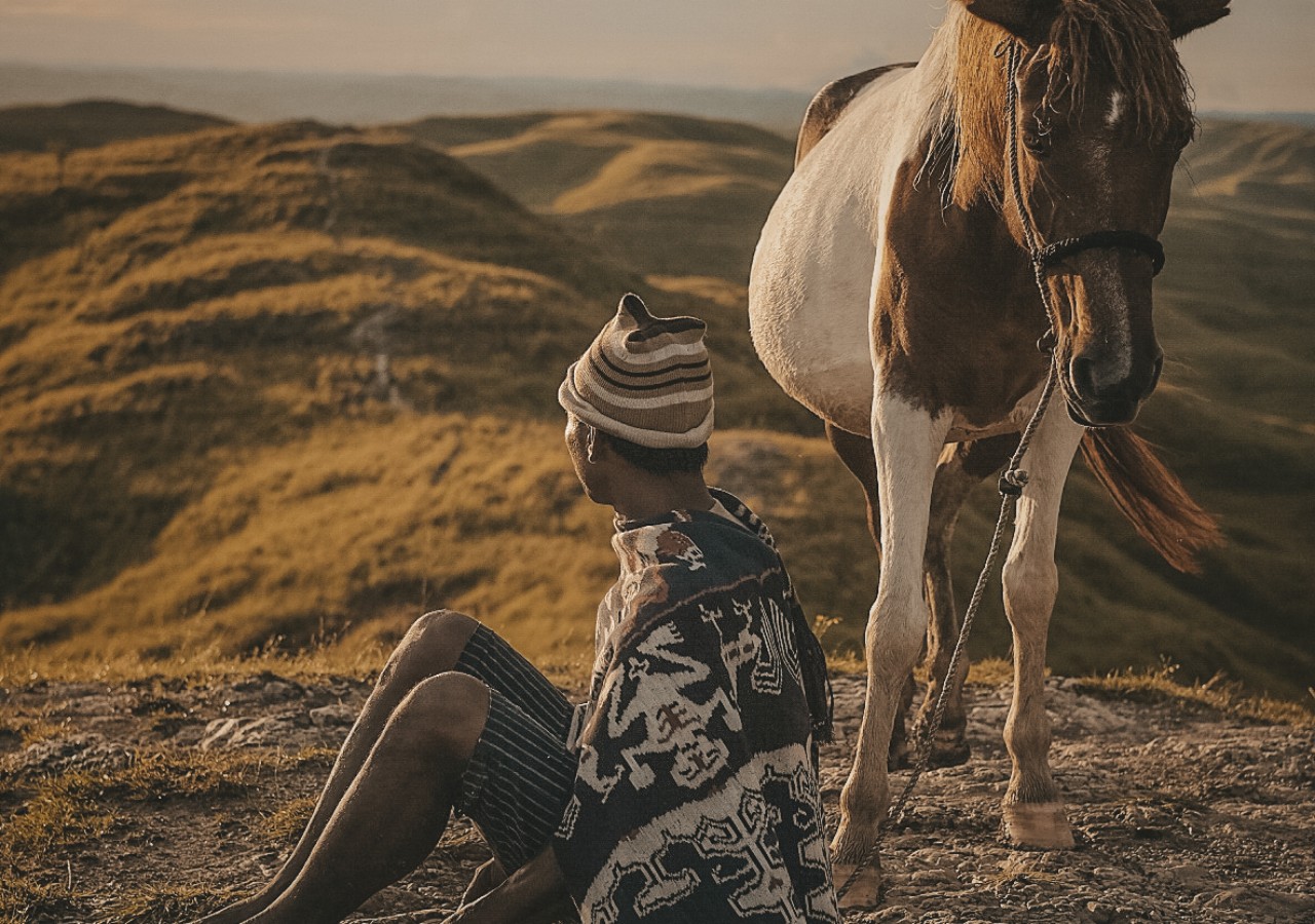 Gente sumbanesa con un caballo en una colina
